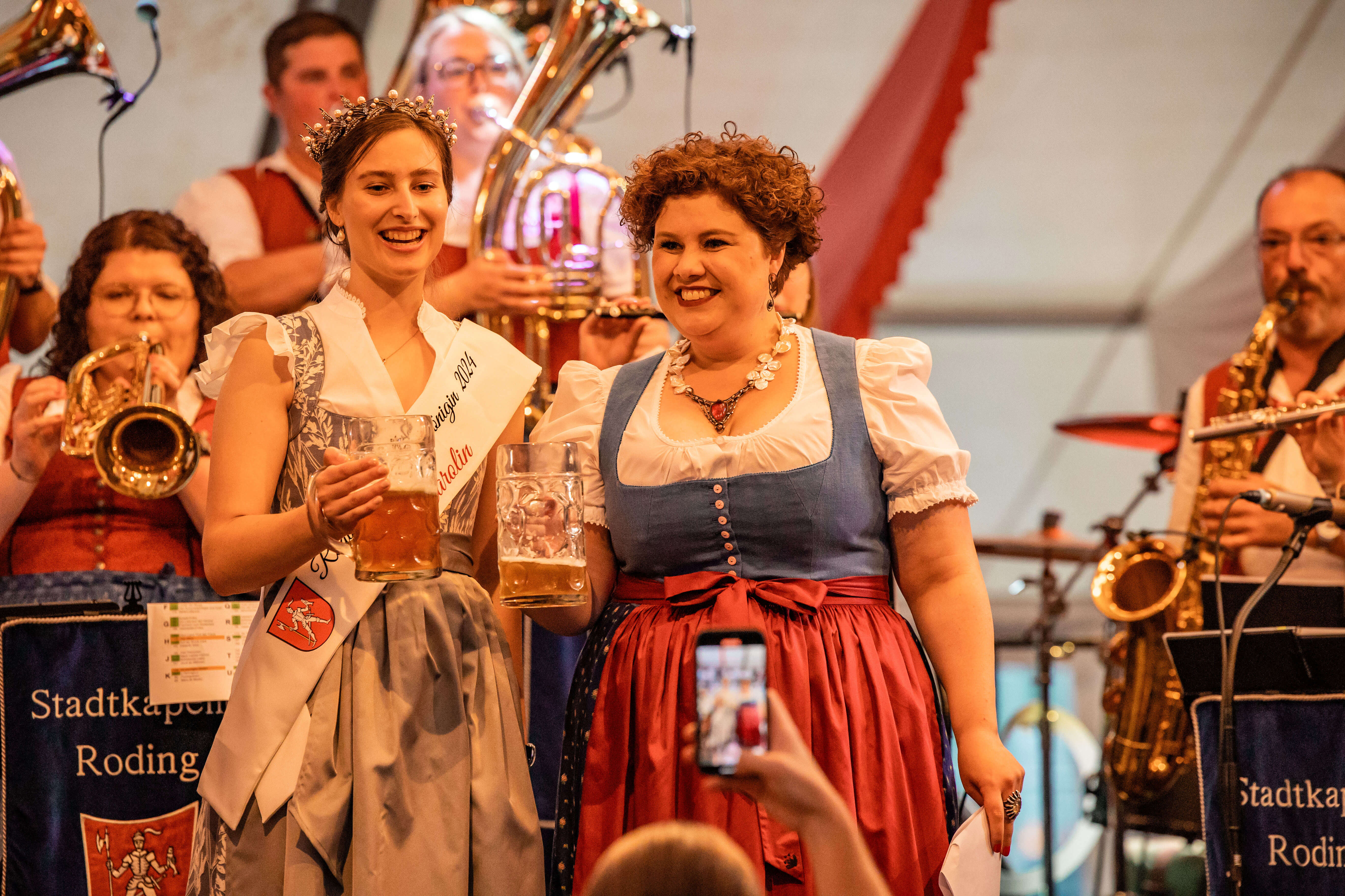 Volksfestkönigin mit der Bürgermeisterin halten einen Bierkrug auf der Bühne
